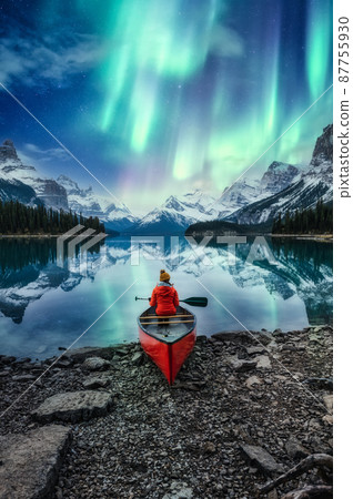 Beautiful aurora borealis over spirit island with female traveler on canoe at Jasper national park 87755930