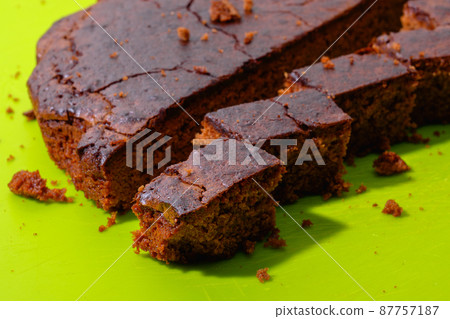 Sweet chocolate cake isolated on green background. Tasty creamy cake. 87757187