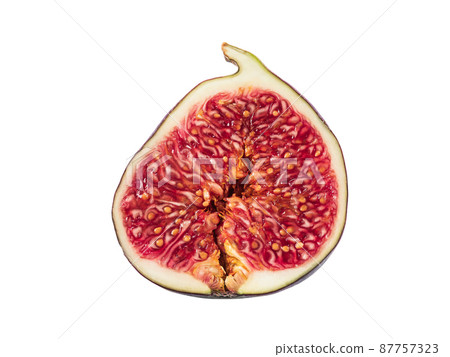 Half of a purple fig isolated on white background with copy space. Soft, sweet fruit, skin is thin, red flesh has many seeds inside of it. Close-up. 87757323