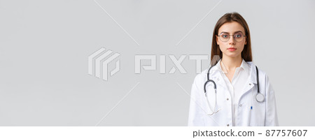 Healthcare workers, medicine, insurance and covid-19 pandemic concept. Serious-looking smart professional doctor, nurse in white scrubs and stethoscope, look camera determined, grey background 87757607