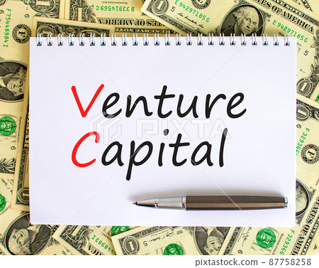 VC venture capital abbraviation symbol. Concept words VC venture capital on white note. Metallic pen. Dollar bills. Beautiful white background. Copy space. Business and VC venture capital concept. 87758258