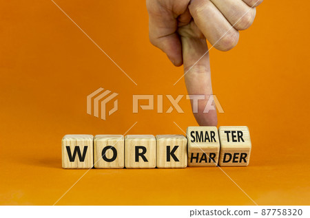 Work harder or smarter symbol. Businessman turns wooden cubes and changes words 'work harder' to 'work smarter'. Beautiful orange background, copy space. Business and work harder or smarter concept. Work harder or smarter symbol. Businessman turns wooden cubes and changes words 'work harder' to 'work smarter'. Beautiful orange background, copy space. Business and work harder or smarter concept. 87758320