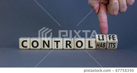 Control habits and life symbol. Businessman turns wooden cubes and changes words 'control habits' to 'control life'. Beautiful grey background, copy space. Business and control habits concept. 87758350