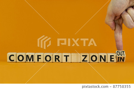 Out or in comfort zone symbol. Businessman turns wooden cubes and changes words Comfort zone in to Comfort zone out. Beautiful orange background, copy space. Business, psychology comfort concept. 87758355