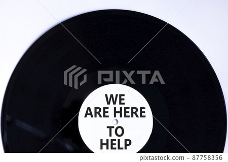 Support and help symbol. Concept words We are here to help on retro black vinyl disc. Beautiful white background, copy space. Business and support concept. 87758356