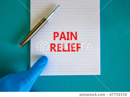 Pain relief symbol. White note with words Pain relief, beautiful blue background, doctor hand in blu glove and metallic pen. Medical and pain relief concept. Pain relief symbol. White note with words Pain relief, beautiful blue background, doctor hand in blu glove and metallic pen. Medical and pain relief concept. 87758358