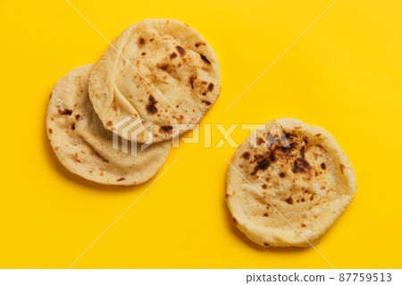 Egyptian bread Aish Baladi on. A lot of fresh bread lies on the yellow table 87759513