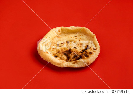 Egyptian bread Aish Baladi. Fresh bread lies on the red table 87759514