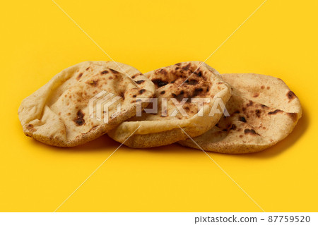 Egyptian bread Aish Baladi on. A lot of fresh bread lies on the yellow table Egyptian bread Aish Baladi on. A lot of fresh bread lies on the yellow table 87759520