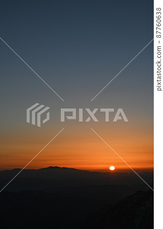 Alps and sunset during the snowy season: The sun setting on the horizon, the sun, and Hakusan in Kaga Alps and sunset during the snowy season: The sun setting on the horizon, the sun, and Hakusan in Kaga 87760638