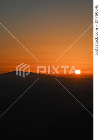 Alps and sunset during the snowy season: The sun setting on the horizon, the sun, and Hakusan in Kaga 87760646