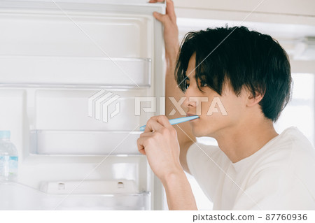 A young man brushing a tooth A young man brushing a tooth 87760936