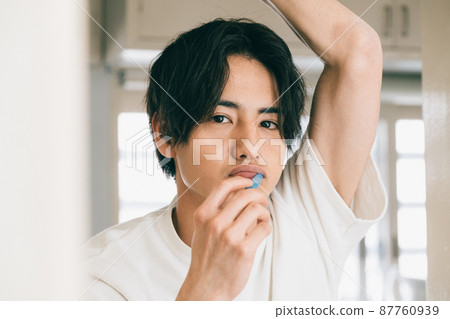 A young man brushing a tooth 87760939