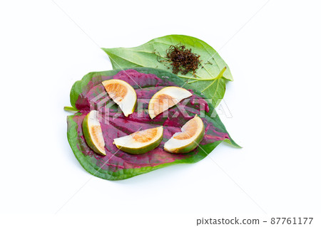 Chewing betel nut, Betel nut with cal lime powder on betel leaves 87761177