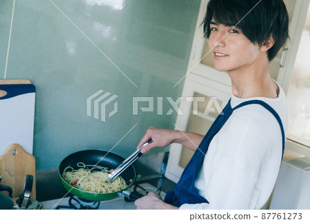 A young man cooking 87761273