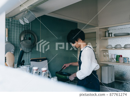A young man cooking A young man cooking 87761274