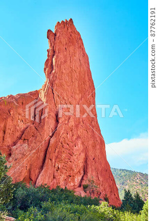 Large vertical pillar of red rock in desert 87762191