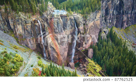 Two waterfalls over giant cliff wall with power station at top Two waterfalls over giant cliff wall with power station at top 87762525