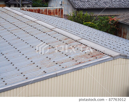 Warehouse metal roof that has begun to corrode Warehouse metal roof that has begun to corrode 87763012