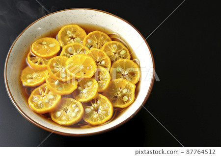 A bird's-eye view of hot sudachi soba with a lot of sudachi slices on a black background 87764512