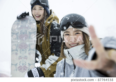 擺在一個多雪的滑雪勝地的單板滑雪女孩 擺在一個多雪的滑雪勝地的單板滑雪女孩 87764538