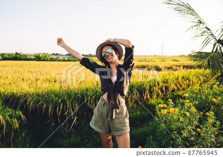 Joyful woman in sunglasses and straw hat rejoicing during travel vacations in Asia Joyful woman in sunglasses and straw hat rejoicing during travel vacations in Asia 87765945