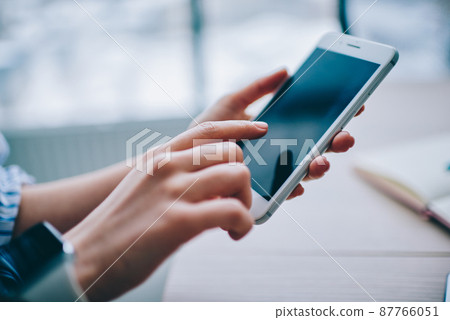 Crop faceless woman using tablet in light room 87766051