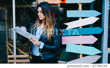 Young woman with map near signs 87766356
