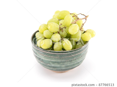 Green grape in green ceramic bowl isolated on white background 87766513