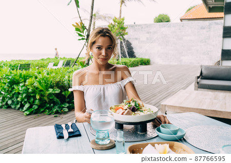 Young woman having lunch in outdoors cafe Young woman having lunch in outdoors cafe 87766595