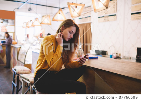 Pensive woman reading messages on smartphone 87766599