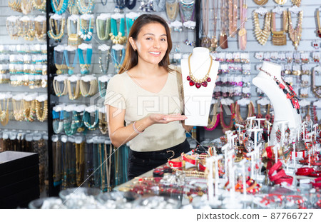 Female salesperson demonstrates gemstone necklace in store Female salesperson demonstrates gemstone necklace in store 87766727