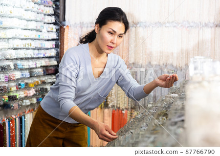 Interested asian woman choosing bijouterie in jewelry store Interested asian woman choosing bijouterie in jewelry store 87766790
