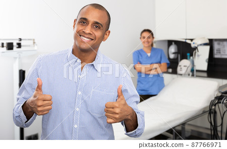 Man client giving thumbs up in aesthetic medicine clinic Man client giving thumbs up in aesthetic medicine clinic 87766971