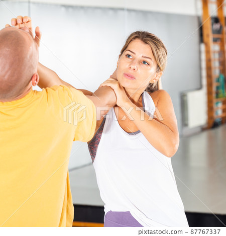 Girl using palm to launch blow in chin during self defence training 87767337