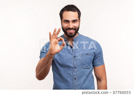 Everything is fine. Satisfied bearded man boss showing ok gesture with fingers, approving work, satisfied with quality. Indoor studio shot isolated on white background Everything is fine. Satisfied bearded man boss showing ok gesture with fingers, approving work, satisfied with quality. Indoor studio shot isolated on white background 87768055
