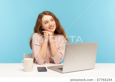 Woman employee sitting at workplace and dreaming of vacation, resting on break, relaxing with thoughtful meditative expression, fantasizing and planning weekend while working at home office. indoor 87768284