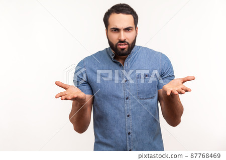 Annoyed stressed man with beard asking what do you want and spreading hands, seriously looking at camera, family quarrel, misunderstanding. Indoor studio shot isolated on white background 87768469