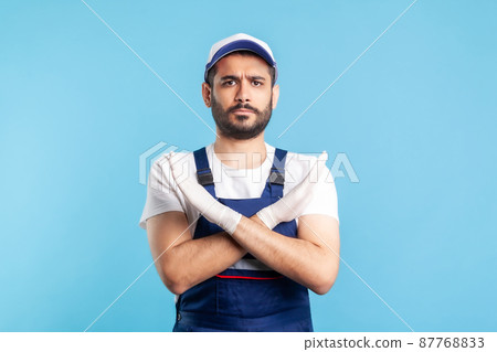 No way, prohibited. Handyman in overalls and gloves gesturing stop with crossed hands. Profession of service industry, courier delivery, housekeeping maintenance. Worker in uniform warning of ban No way, prohibited. Handyman in overalls and gloves gesturing stop with crossed hands. Profession of service industry, courier delivery, housekeeping maintenance. Worker in uniform warning of ban 87768833
