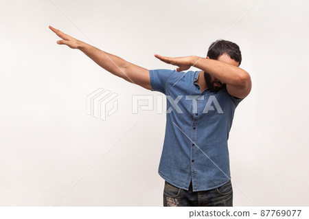 Excited positive man raising hands making dubdance move, celebrating victory, triumph, showing popular internet trend. Indoor studio shot isolated on white background 87769077