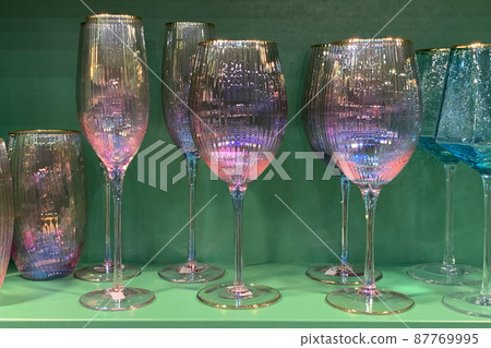 collection of beautiful colourful glasses on wooden cabinet shelf 87769995