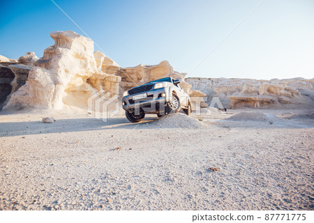 Vehicle standing in sandy valley in daylight 87771775