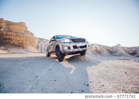 Automobile parked in dry desert in daylight 87771791
