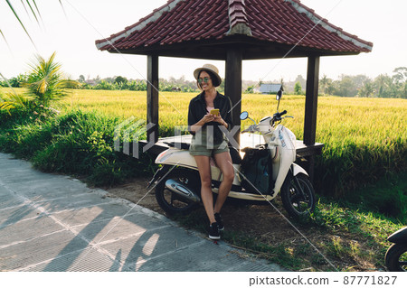 Cheerful Caucasian blogger using cellphone gadget and vintage transport in Indonesia Cheerful Caucasian blogger using cellphone gadget and vintage transport in Indonesia 87771827
