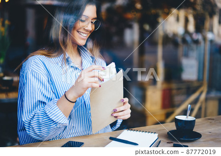 Happy woman with envelope in cafe Happy woman with envelope in cafe 87772019