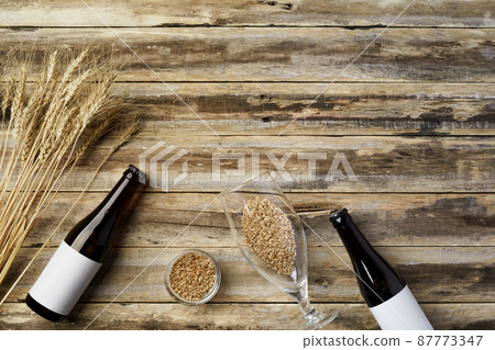 A bottle of beer and grain. Top view. Free space for text. 87773347