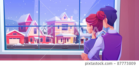 Couple looking at window at snowfall on street 87773809