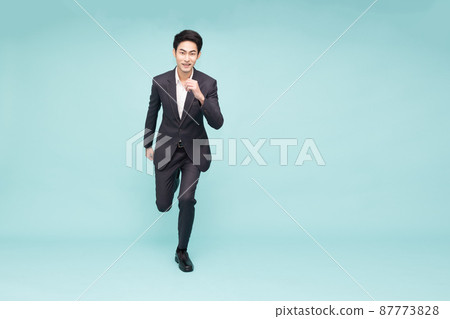 Young Asian businessman running forward isolated on green background Young Asian businessman running forward isolated on green background 87773828