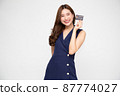 Young beautiful Asian woman smiling, showing, presenting credit card for making payment or paying online business, Pay a merchant or as a cash advance for goods, Cardholder or A person who owns a card 87774027