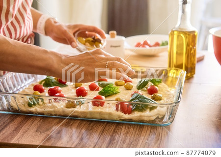Woman cooking Italian focaccia bread at home. Selected fresh ingredients. Cooking process. Country 87774079